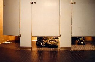 Student sitting in bathroom stall