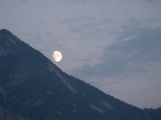 The moon slides downhill near Levico, Trento, Italy