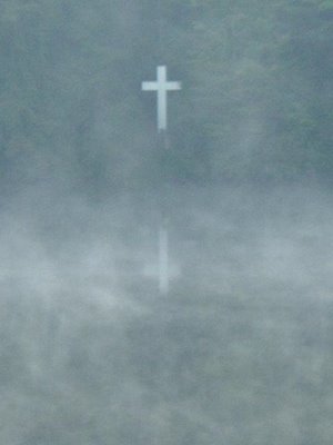 looking across western North Carolina's foggy Lake Kanuga at a large white cross, early in the morning, September 2005