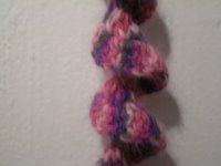 close up image of narrow crocheted spiral scarf in pink and gray angora yarn