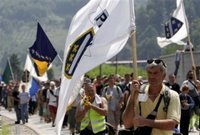 Bosnian people carrying Bosnian flags finish their four-day march to Srebrenica as they enter to the Memorial Center Potocari, near Srebrenica north of Bosnian capital Sarajevo, Monday, July 10, 2006. Hundreds of Bosnians began a four-day march on Friday along the route survivors used 11 years ago to escape the Bosnian Serb killings in Srebrenica, the worst massacre in Europe since World War II. March was a part of ceremony marking 11th anniversary of Srebrenica fall. Serb troops killed over 8,000 Bosniak men and boys at Srebrenica in 1995, and most of the bodies are still missing. (AP Photo/Amel Emric)