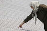 A Bosnian Muslim woman points to the name of her relative on the marble stone with 8,370 names of Srebrenica victims written on it, at the Memorial Center at Potocari, near Srebrenica north of the Bosnian capital Sarajevo, on Sunday July 9, 2006. The bodies of 505 newly identified Srebrenica victims will be buried in Srebrenica on Tuesday (July 11th) during the 11th anniversary commemorations of the massacre. Serb troops killed over 8,000 Bosniak men and boys at Srebrenica in 1995, and most of the bodies are still missing. (AP Photo/Amel Emric)