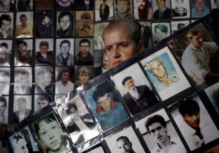 Bosniak (Bosnian Muslim) woman Hajra Catic, 60, who is a survivor of the Srebrenica massacre stands next to dozens of photos of the missing Srebrenica citizens, after this safe U.N. enclave fell into Bosnian Serb hands in July 1995, at the Association of Srebrenica widows in Tuzla, on Friday, July 7, 2006. Preparations are being made for the upcoming funeral of 500 victims on the 11th anniversary of the fall of Srebrenica. The 500 newly identified bodies of Muslims killed in the worst massacre of civilians since World War II will be buried next Tuesday.(AP Photo/Amel Emric)