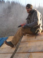 Christoph Lotter applies roofing steel to the new woodshed.