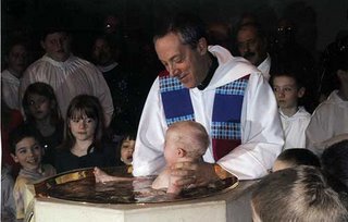 Photo of Fr. Sarkies baptizing a baby.