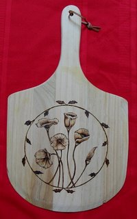 Pizza peel decorated with woodburned California poppies.