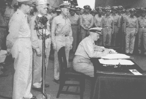USS Missouri in Tokyo Bay, September 2, 1945<br />Admiral Nimitz, with General MacArthur and Admirals Halsey and Forrest Sherman standing directly behind him, signs the Japanese surrender document on behalf of the United States. General MacArthur had earlier signed on behalf of the Allied Nations.