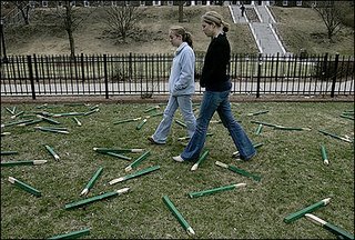 College of The Holy Cross students Sarah Fontaine (left) and Molly Haglund, who helped create the installation on the Iraq war, passed through the vandalized display yesterday. (Suzanne Kreiter/ Boston Globe Staff photo)