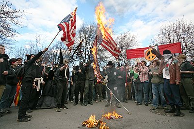 A small group of anarchists marched during last March's demonstration marking the anniversary of the Iraq war.  They burned their own flags at the end of the march with the tacit approval of the police who stood by and watched, but made no arrests.  They were not affiliated with those holding peace signs in the background.