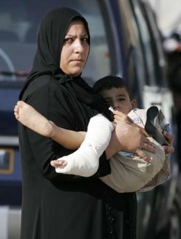 Mother carrying her injured son. The boy was wounded in the overnight rocket attacks in Baghdad August 31st 2006