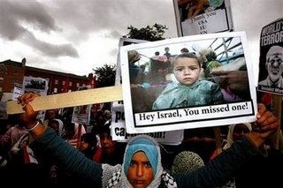 A protester holds up a sign showing a refugee child with the slogan 'Hey Israel! You Missed One' Parnell Square Dublin July 29 2006