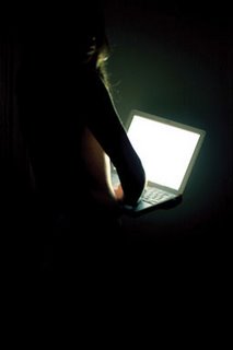Woman using a laptop in the dark by Mareen Fischinger