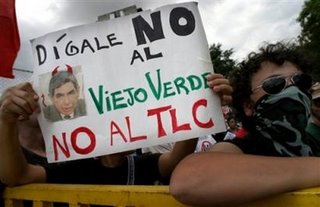 An unidentified person holds a poster reading 'Say no to the green old man, say no to the TLC (Free Trade Agreement)' and showing a photo of new President Oscar Arias during a demonstration against CAFTA and Arias's presidential inauguration on Monday May 8, 2006 in San Jose, Costa Rica near the National Stadium. (AP Photo/Cristobal Herrera)