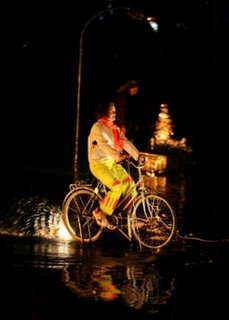 A french performer rides a bike on the water of the lake of La Sabana Park.