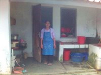 Ceu Ana di dapur asrama dengan baju dinasnya