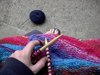 Me knitting. It's not in motion 'cause no one was around to take a photo for me. I typically knit in my sweats which is what I am wearing here and slippers or sandals. I always knit contintal for stockinette in the round, although right before this I experimented with left-handed purling.