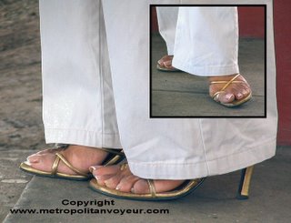 Glamour removing trousers from golden strap sandals