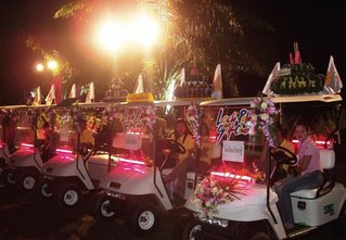Golf carts from the country club carry kratongs