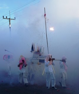 Carrying the god statues through the smoke and firecrackers
