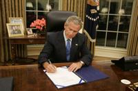 President George W. Bush signs legislation in the Oval Office Friday, Sept. 2, 2005, to provide 10.5 billion dollars in relief aid for the areas along the Gulf Coast affected by Hurricane Katrina. Congress approved the bill late Thursday. White House photo by Paul Morse