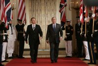 President George W. Bush is joined by Prime Minister Tony Blair of the United Kingdom as they walk through Cross Hall to the East Room of the White House Friday, July 28, 2006, to participate in a joint press availability. White House photo by Paul Morse.