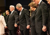 President George W. Bush and Mrs. Laura Bush are seen during a prayer holding hands with former President Bill Clinton, right, and Rev. Robert Schuller, left, at the homegoing celebration for Coretta Scott King, Tuesday, Feb. 7, 2006 at the New Birth Missionary Church in Atlanta, Ga. White House photo by Eric Draper.