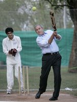 President George W. Bush watches his hit during a cricket clinic with members of the Islamabad College for Boys at the Raphel Memorial Gardens on the grounds of the U.S. Embassy in Islamabad, Pakistan. White House photo by Eric Draper,