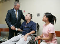 President George W. Bush shakes the hand of SFC Richard Robertson, of Knoxville, Tenn., Wednesday, Oct. 5, 2005, as his wife, Sarah Robertson, looks on. President Bush presented the Purple Heart to the soldier during his visit to Walter Reed Army Medical Center in Washington D.C. White House photo by Paul Morse