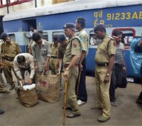 Police officers check the bags of passengers in a train at the Sealdah railway station in Calcutta, India, Wednesday, July 12, 2006. [© AP/WWP]