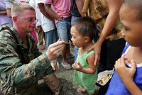 U.S. Marines Sgt. Matthew Meodor lets a landslide evacuee taste his MRE (Meals-Ready-to-Eat) ration during their humanitarian mission at an evacuation center in St. Bernard town near the village of Guinsaugon, Leyte province in central Philippines Tuesday Feb.21, 2006. More than 3,000 evacuees trooped to evacuation centers following Friday's massive landslide which buried the entire village of Guinsaugon killing hundreds of villagers, including about 200 school children. This young boy's two elder brothers were killed in the landslide. © AP/WWP