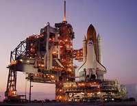 Amid the glow of lights from the fixed and rotating service structures, Space Shuttle Discovery rests on the hardstand of Launch Pad 39B at NASA's Kennedy Space Center. Photo credit: NASA/Ken Thornsley.