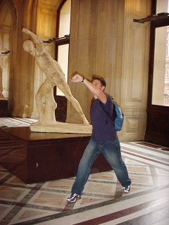 Chad posing with a statue in the Louvre