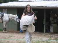 Emily carrying her saddle