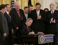 President George W. Bush signs into law S. 3930, the Military Commissions Act of 2006, during a ceremony Tuesday, Oct. 17, 2006, in the East Room of the White House. Joining him on stage, from left are: Utah Rep. Chris Cannon, Indiana Rep. Steve Buyer, Wisconsin Rep. Jim Sensenbrenner, Sen. Lindsey Graham of South Carolina, California Rep. Duncan Hunter, and Sen. John Warner of Virginia. General Peter Pace, Chairman of the Joint Chiefs of Staff, and U.S. Attorney General Alberto Gonzales are in the background. White House photo by Paul Morse.