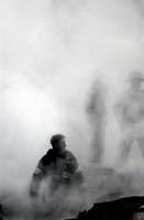 A fire fighter emerges from smoke and debris of the World Trade Center Sept. 14, 2001, in New York. The twin towers of the center were destroyed in the Sept. 11th terror attack. Photo by Photographer's Mate 2nd Class Jim Watson, USN