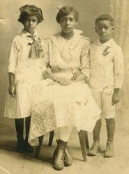 Fotografia data de 1880. Uma mulher e duas crianças, sem registo de nomes.