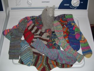 a big pile of socks with an alpaca on top