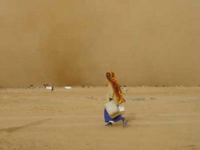 A storm kicks up fine orange sand in Oure Cassoni camp in the northern part of Chad's border with Sudan July 19, 2004. Soon the dry weather will be replaced by the rainy season, which will complicate efforts to bring relief aid to the almost 200,000 Sudanese refugees who have fled to Chad. (Gauthier Lefevre/IFRC via Reuters)