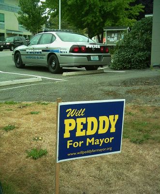 Peddy sign in foregorund of police station