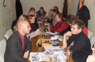 People sitting along a long table, having fun