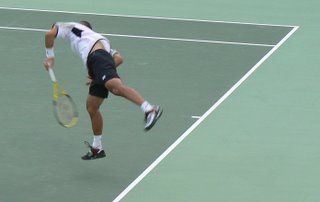 The Japanese tennis player leaves the ground as he puts all his effort into his serve