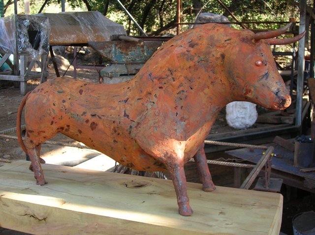 toro. escultura en hierro reciclado. patina oxidada. base de madera nativa . 0.50 cms x 0.70 de lar