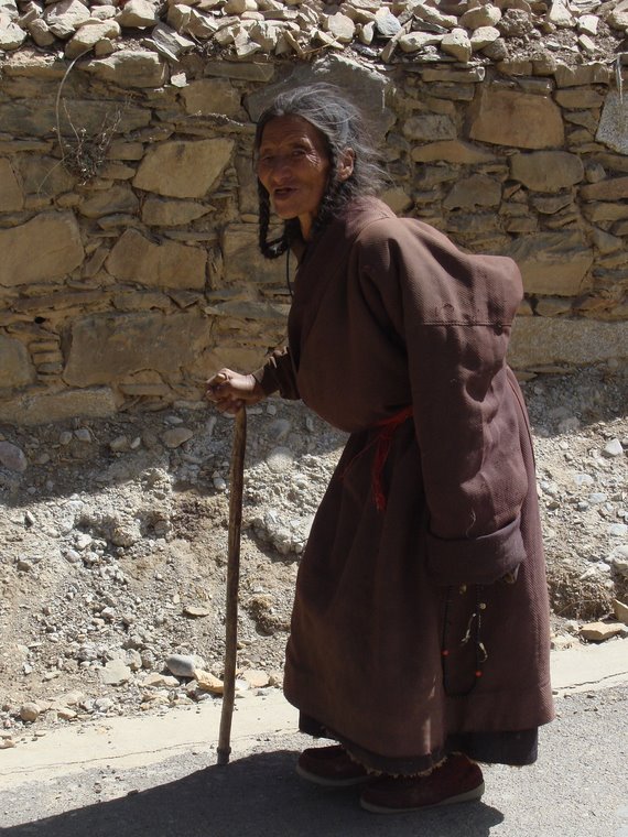 Tibetan elderly woman on her way to the monastery