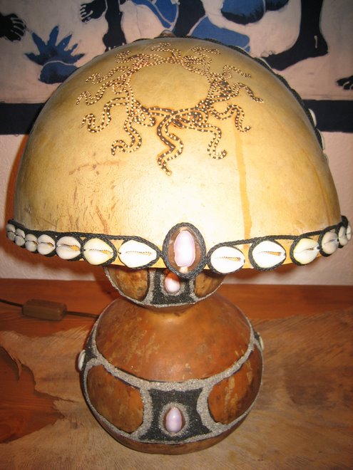 lampe de bureau en calebasse , avec soleil tribal,decoré de sable noir volcanique,et coquillages.