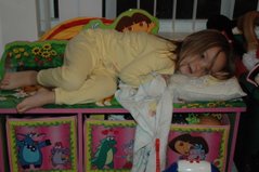 Elani-pretending to sleep on her toy box