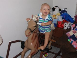 Matthew smiling on a rocking horse