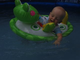 Matthew laughing while floating in a pool toy