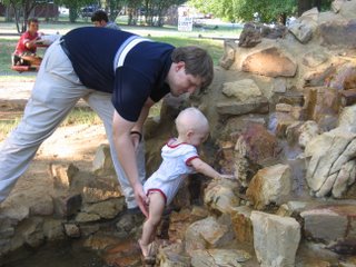 Matthew climbing up a rock fountain with Rick's help
