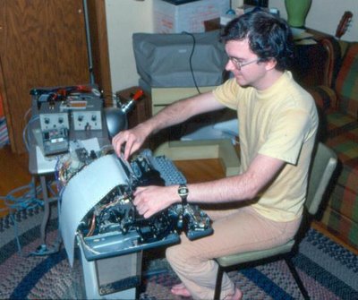 Thomas Kraemer in 1977 using a torn apart Model 33 Teletype hooked up via a serial current loop to an SC/MP microprocessor board