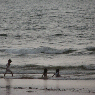  Lapset leikkivät rantavedessä Goan uimarannalla